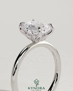 Kynora CJ 2ct emerald claw solitaire engagement ring with petal gallery and accent leaf details, showcasing intricate jewelry craftsmanship.