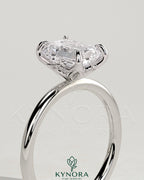 Kynora CJ 2ct emerald claw solitaire engagement ring with petal gallery and accented tiara detail, showcasing intricate design and sparkling gemstone.