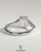 Kynora CJ 2ct emerald claw solitaire engagement ring with round shoulder stones, featuring a striking emerald centerpiece and detailed band.