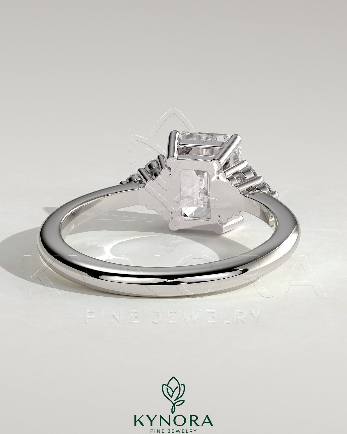 Kynora CJ 2ct emerald claw solitaire engagement ring with round shoulder stones, featuring a striking emerald centerpiece and detailed band.