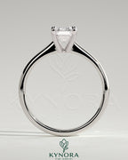 Kynora CJ 2ct emerald claw solitaire engagement ring with tapered band and cathedral low setting, showcasing a sparkling emerald gemstone.