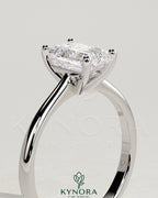 Kynora CJ 2ct emerald claw solitaire engagement ring with tapered band and cathedral low setting, showcasing a sparkling emerald gemstone.