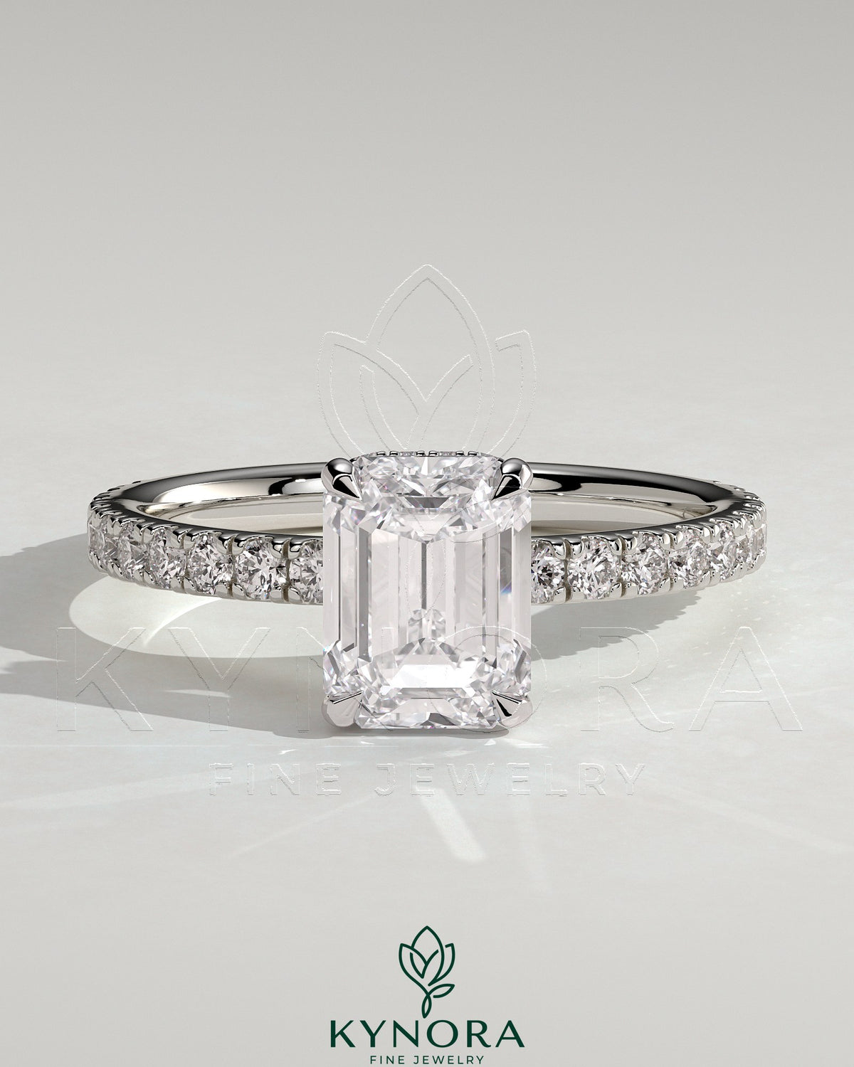 Kynora CJ 2ct emerald claw solitaire engagement ring with wrap-around hidden halo and pave band, showcasing a dazzling center stone. Main image