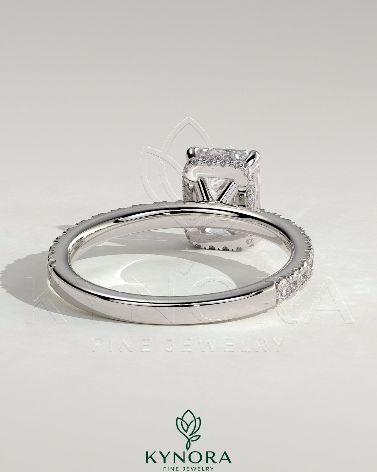 Kynora CJ 2ct emerald claw solitaire engagement ring with wrap-around hidden halo and pave band, showcasing intricate design and sparkle.