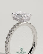 Kynora CJ 2ct emerald claw solitaire engagement ring with wrap-around hidden halo and pave band, showcasing intricate design.