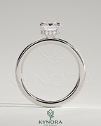 Kynora CJ 2ct emerald claw solitaire engagement ring with a wrap-around hidden halo in gold, featuring a central emerald cut gemstone.