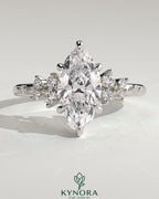 Kynora CJ 2ct marquise solitaire engagement ring with clustered round shoulder stones, crafted in elegant jewelry style.