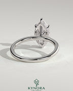 Kynora CJ 2ct marquise claw solitaire engagement ring with a wrap-around hidden halo and intricate band design.