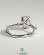 Kynora CJ 2ct oval claw solitaire engagement ring with six round accent stones and a hidden halo design.