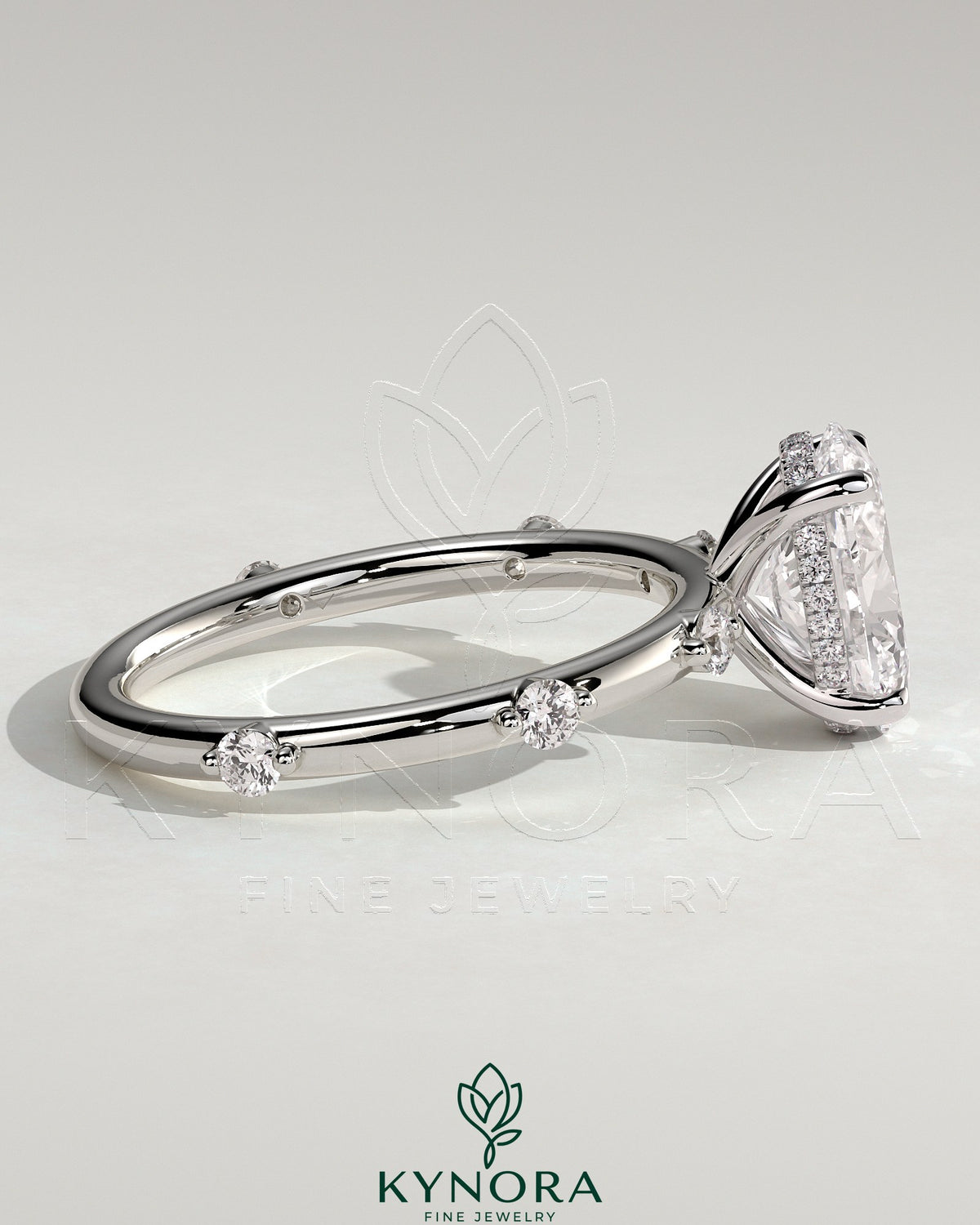 Kynora CJ 2ct oval claw solitaire engagement ring with six round accent stones and hidden halo setting.