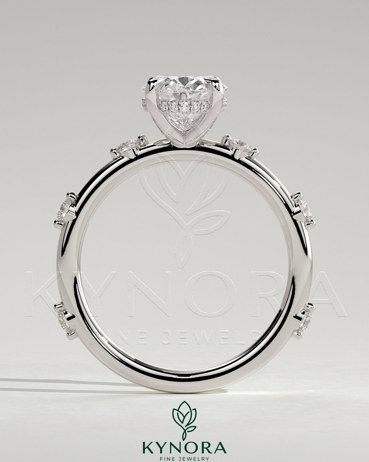 Kynora CJ 2ct oval claw solitaire engagement ring with six round accent stones and hidden halo setting.