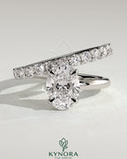 Kynora CJ 2ct oval claw solitaire engagement ring with angled pave band, featuring a sparkling oval diamond and intricate band design.