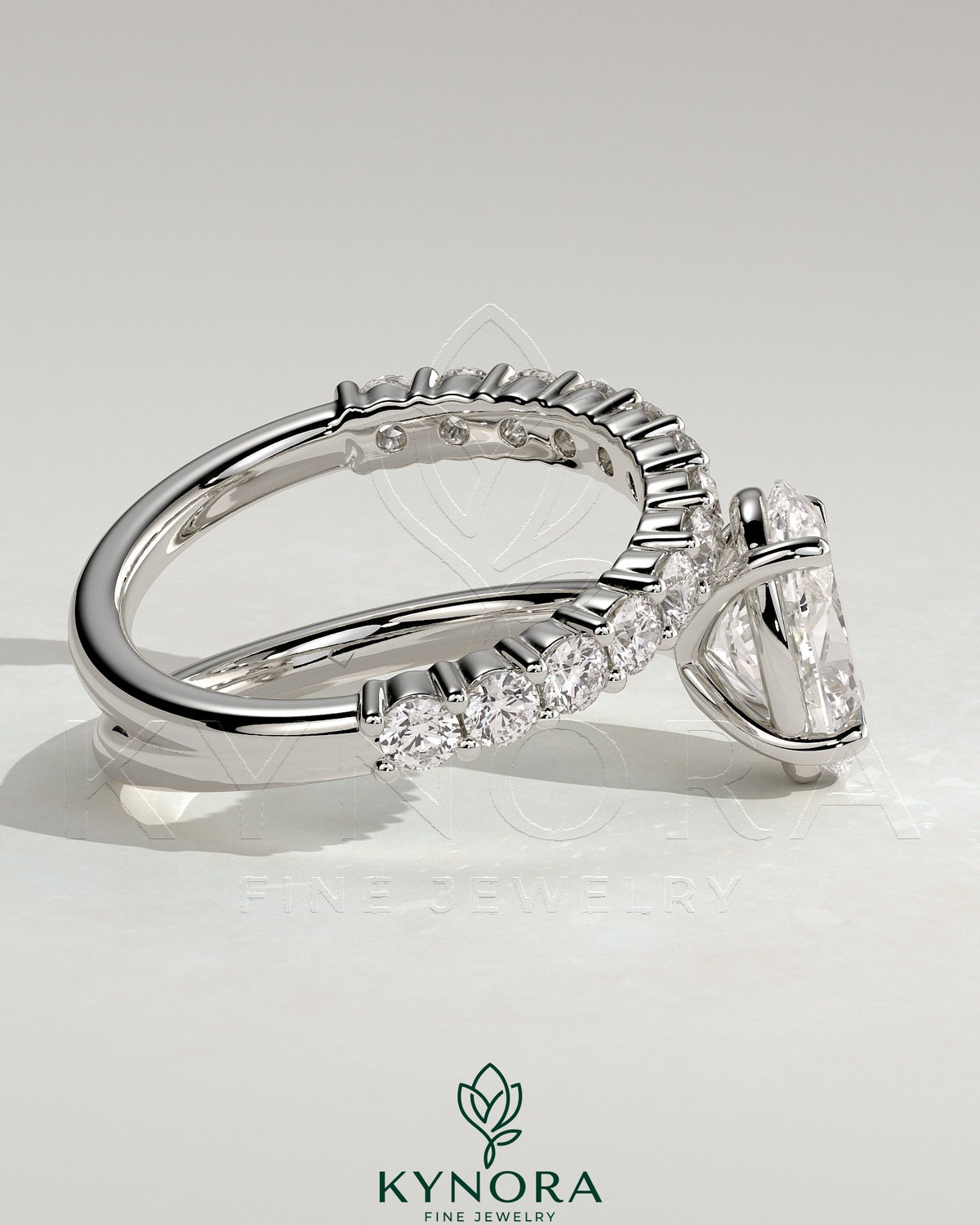 Kynora CJ 2ct oval claw solitaire engagement ring with angled pave band, showcasing a sparkling oval diamond and detailed band design.