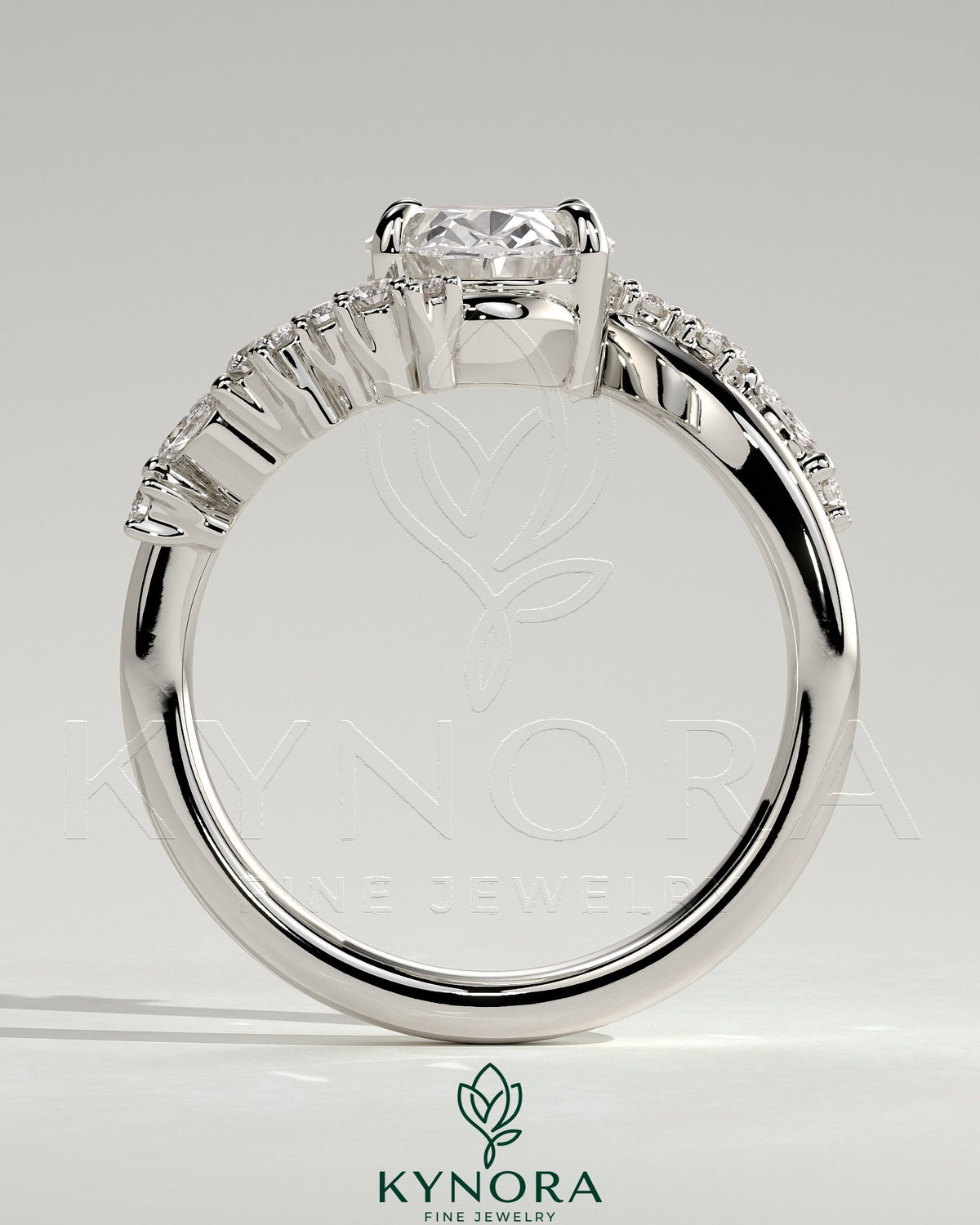 Kynora CJ 2ct oval claw solitaire engagement ring with bypass band and clustered round-marquise accent stones.