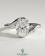 Kynora CJ 2ct oval claw solitaire engagement ring with bypass band, showcasing a sparkling oval diamond and sleek gold setting