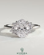 Kynora CJ 2ct oval claw solitaire engagement ring with clustered round shoulder stones and sleek band design.