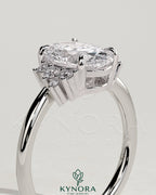 Kynora CJ 2ct oval claw solitaire engagement ring with clustered round shoulder stones, elegant and sparkling jewelry design.