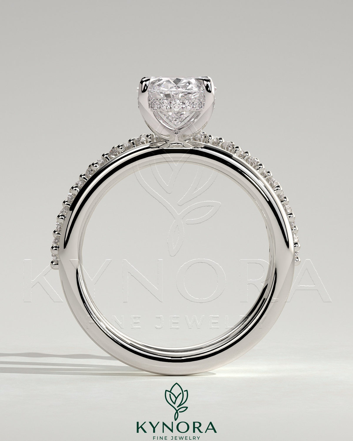 Kynora CJ 2ct oval claw solitaire engagement ring with double band and round accent stones, elegant and sparkling jewelry piece.