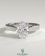 Kynora CJ 2ct oval claw solitaire engagement ring with flat cigar band and hidden halo in polished gold finish.