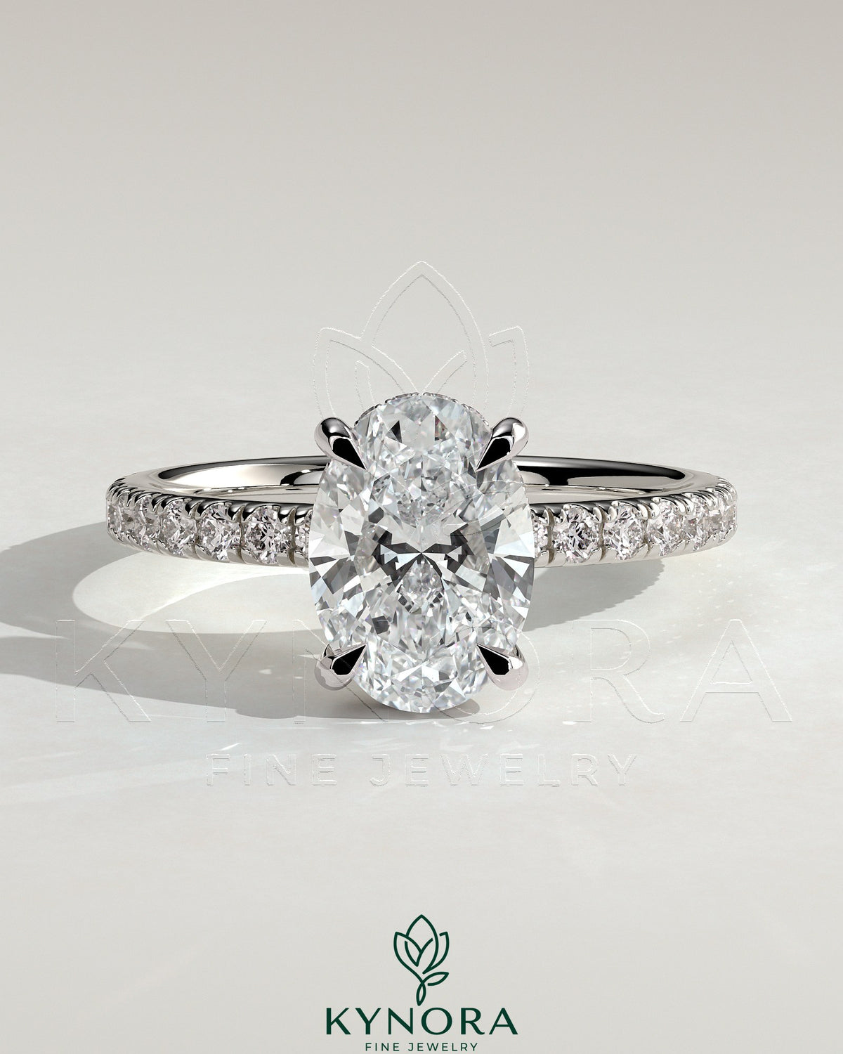 Kynora CJ 2ct oval claw solitaire engagement ring with hidden halo and pave band, showcasing a sparkling central diamond.