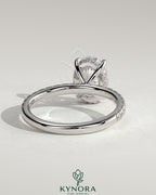 Kynora CJ 2ct oval claw solitaire engagement ring with hidden halo and pave band, showcasing elegant diamond design.