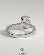 Kynora CJ 2ct oval claw solitaire engagement ring with hidden halo and triple pave band, showcasing sparkling diamond details.