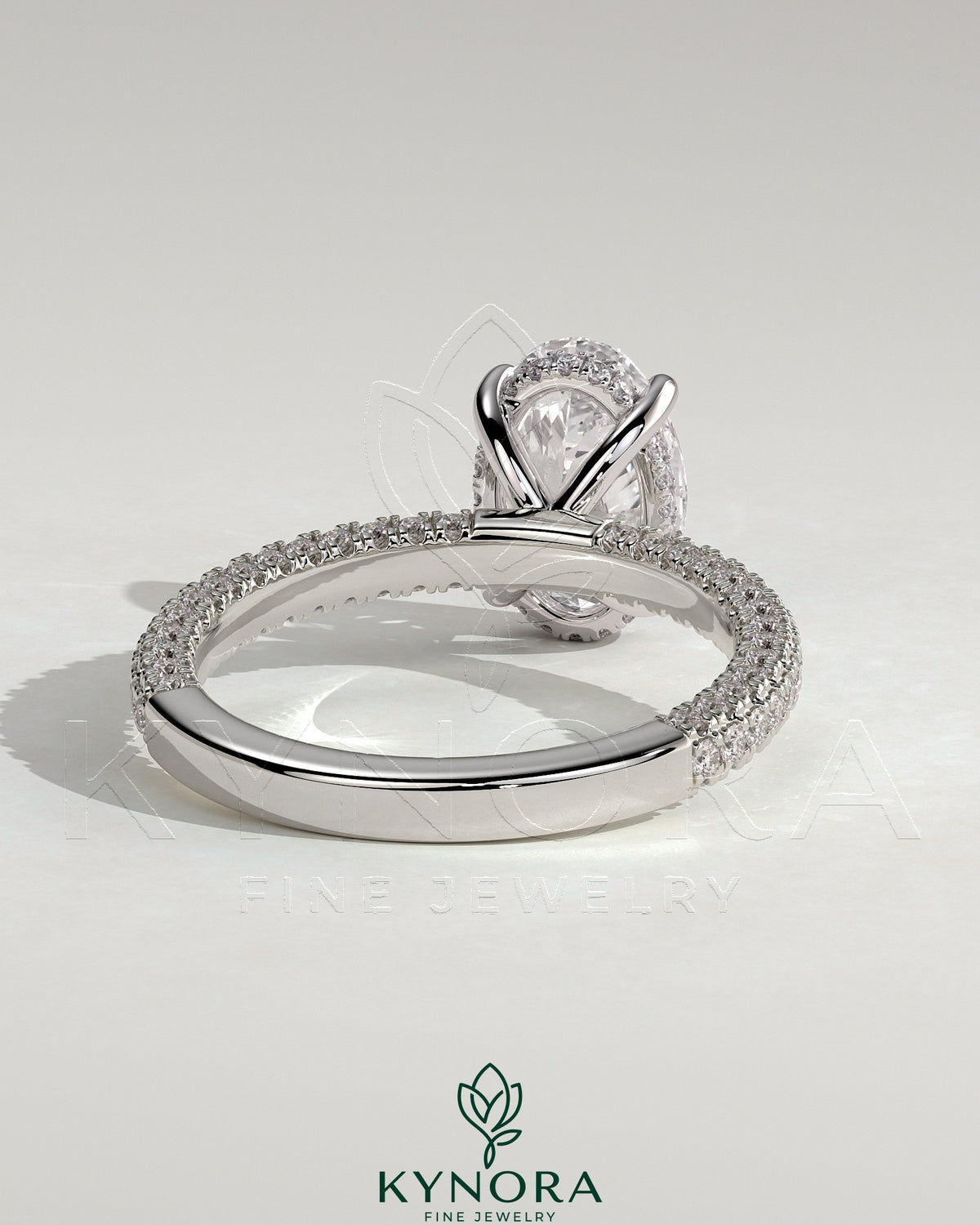 Kynora CJ 2ct oval claw solitaire engagement ring with hidden halo and triple pave band, showcasing sparkling diamond details.