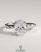 Kynora CJ 2ct oval claw solitaire engagement ring with hidden halo, opposing marquise accents, cathedral high setting.