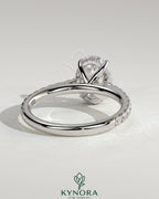 Kynora CJ 2ct oval claw solitaire engagement ring with hidden halo, pave band, and cathedral high setting.