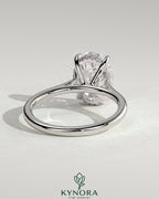 Kynora CJ 2ct oval claw solitaire engagement ring with hidden halo, tapered band, and cathedral high setting, showcasing intricate design.