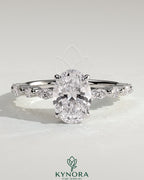 Kynora CJ 2ct oval claw solitaire engagement ring with marquise-round accents and a hidden halo, showcasing elegant jewelry design.