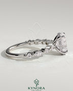 Kynora CJ 2ct oval claw solitaire engagement ring with marquise and round accent stones, featuring a hidden halo design.