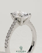 Kynora CJ 2ct oval claw solitaire engagement ring with pave band and cathedral low setting, showcasing elegant diamond design.