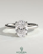 Kynora CJ 2ct oval claw solitaire engagement ring with pinched tapered band and cathedral low setting, showcasing elegant jewelry design.