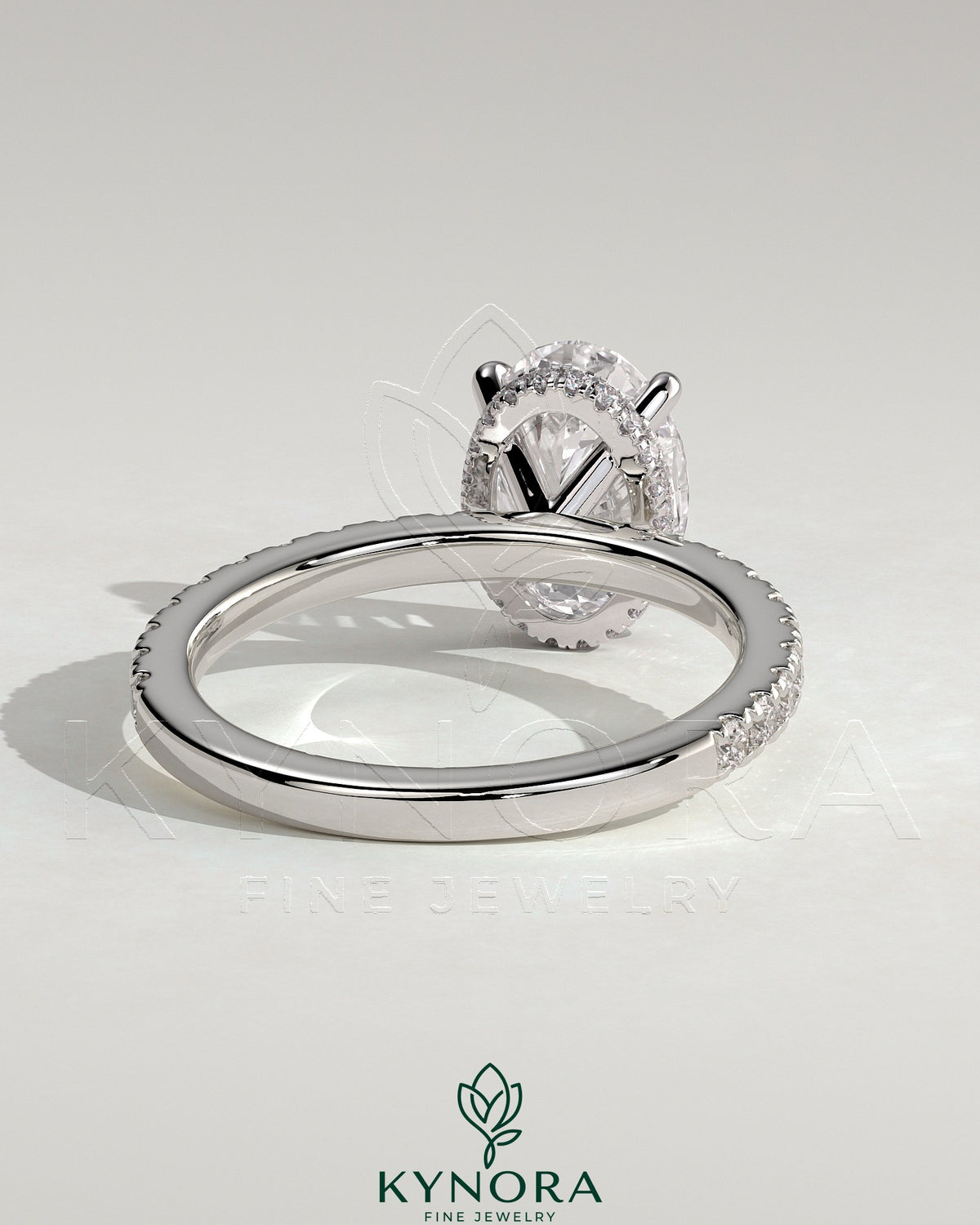 Kynora CJ 2ct oval claw solitaire engagement ring with wrap-around hidden halo and pave band, showcasing elegant jewelry design.