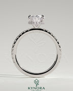 Kynora CJ 2ct oval claw solitaire engagement ring with hidden halo and pave band, featuring intricate metalwork and sparkling diamonds.