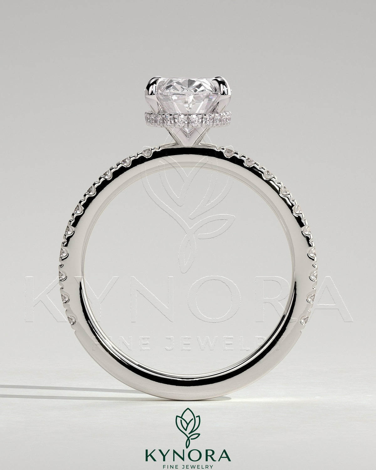 Kynora CJ 2ct oval claw solitaire engagement ring with hidden halo and pave band, featuring intricate metalwork and sparkling diamonds.