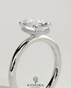 Kynora CJ 2ct oval claw solitaire engagement ring with a wrap-around hidden halo, showcasing a sparkling center stone and intricate design.