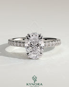 Kynora CJ 2ct oval double claw solitaire engagement ring with hidden halo, pave band, and cathedral high setting, showcasing intricate design.
