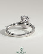 Kynora CJ 2ct oval solitaire engagement ring with double claw setting, hidden halo, pave band, and cathedral high setting.