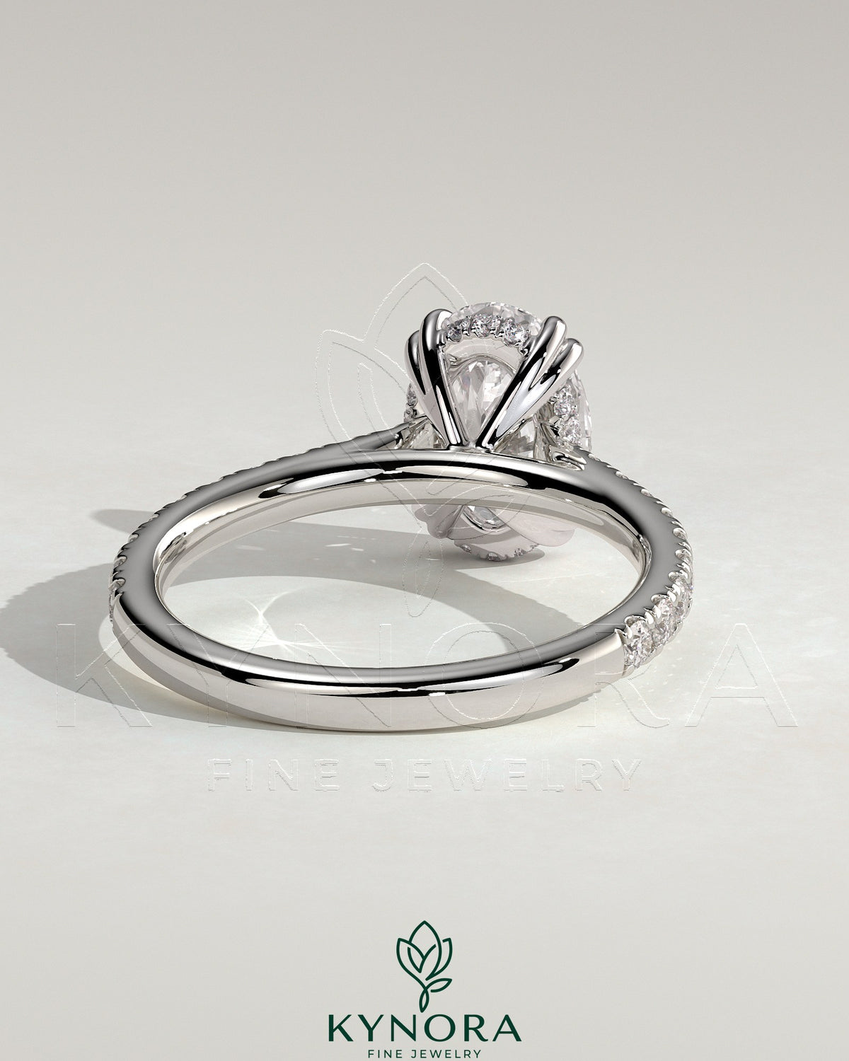Kynora CJ 2ct oval solitaire engagement ring with double claw setting, hidden halo, pave band, and cathedral high setting.