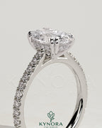 Kynora CJ 2ct oval double claw solitaire engagement ring with hidden halo, pave band, and cathedral high setting.