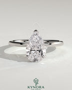 Kynora CJ 2-carat pear-shaped diamond solitaire engagement ring with three prongs on a sleek gold band.