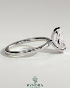 Kynora CJ 2ct pear-shaped diamond solitaire engagement ring with three prongs on a sleek band, showcasing elegant jewelry design.