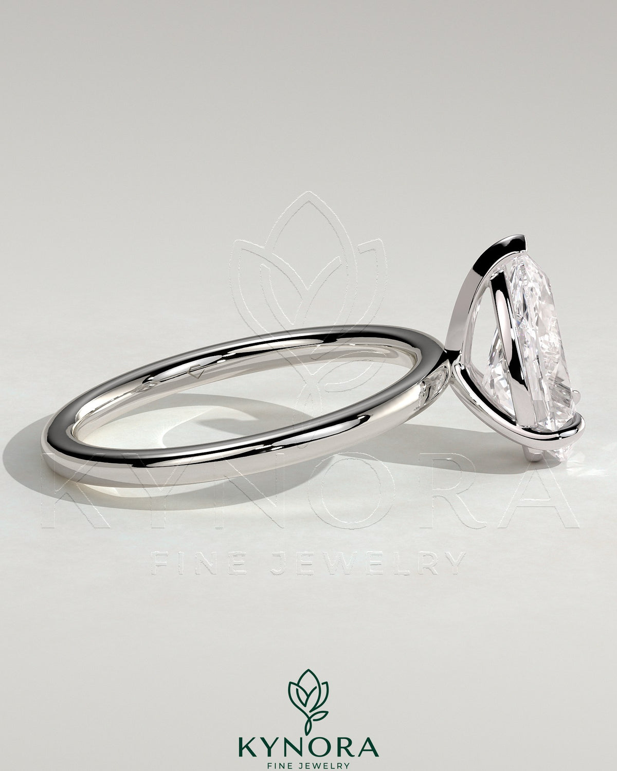 Kynora CJ 2ct pear-shaped diamond solitaire engagement ring with three prongs on a sleek band, showcasing elegant jewelry design.