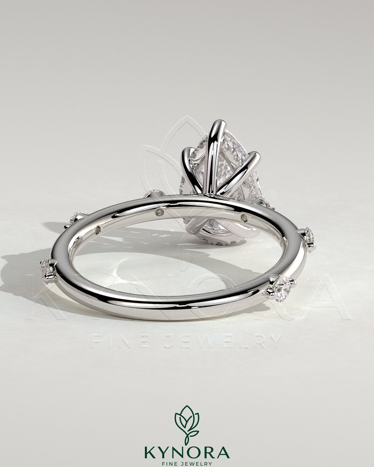 Kynora CJ 2ct pear-shaped diamond solitaire engagement ring with six accent stones and a hidden halo design.