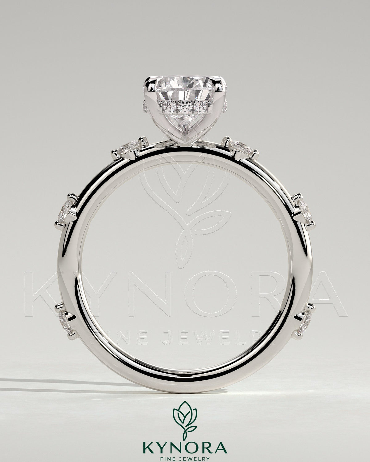 Kynora CJ 2ct pear-shaped solitaire engagement ring with six round accent stones and a hidden halo design.