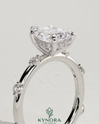 Kynora CJ 2ct pear-shaped diamond solitaire engagement ring with six round accent stones and hidden halo setting.