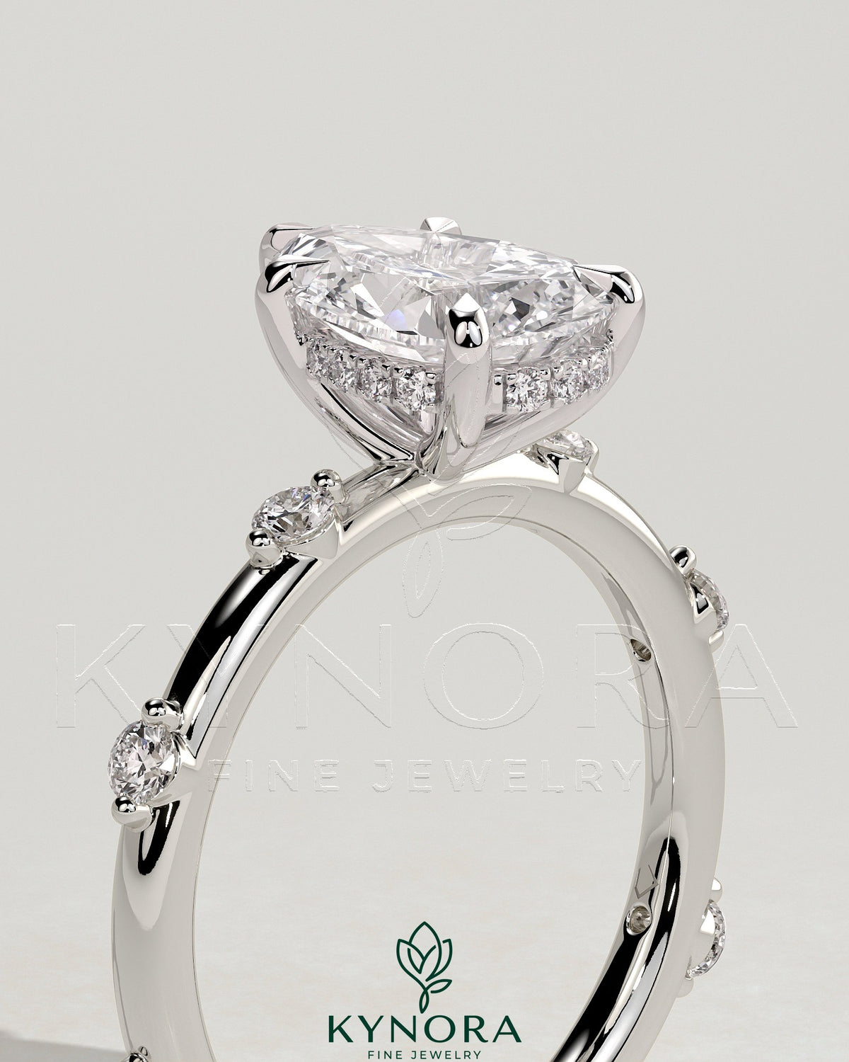 Kynora CJ 2ct pear-shaped diamond solitaire engagement ring with six round accent stones and hidden halo setting.