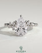 Kynora CJ 2ct pear-shaped diamond solitaire engagement ring with clustered round shoulder stones, crafted in sterling silver.